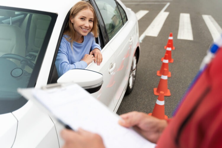 Women in car receiving evaluation for drivers license